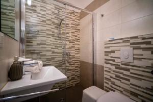 a bathroom with a sink and a glass shower at Hotel Sammaritani in Rimini