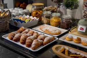 a buffet with several trays of pastries and other foods at Hotel Sammaritani in Rimini +30 photos