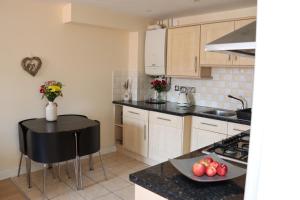 a kitchen with white cabinets and a black counter top at Scandinavian City Centre Apartment in Worcester +41 photos