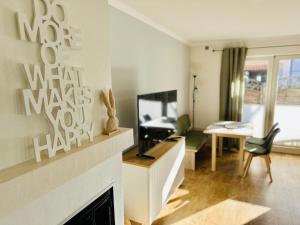 Una sala de estar con televisión y chimenea. en Meer-Lust-Sylt family and friends - 2025 refreshed, en Westerland