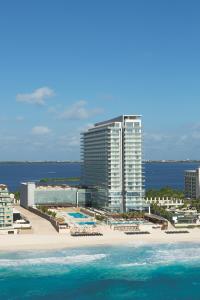a view of a resort with a beach and the ocean at Secrets The Vine Cancun - All Inclusive Adults Only in Cancún