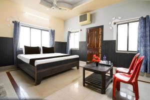 a bedroom with a bed and a table and a chair at Hotel O Jannat in Chupra