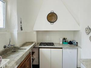 una cucina bianca con fornelli e lavello di Lerici Dream View a Lerici