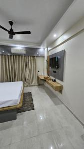 ラクナウにあるComfort innのベッドと薄型テレビのある寝室