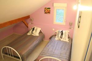 two beds in a small room with pink walls at L'ATELIER, chalet 3* in Vecoux