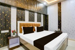 a bedroom with a large bed with black and gold wallpaper at Super Hotel O Radha kunj By Namasya Retreat International in Prayagraj