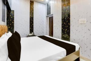a bedroom with a white bed and black and white walls at Super Hotel O Radha kunj By Namasya Retreat International in Prayagraj