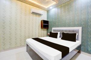 a bedroom with a large white bed in a room at Super Hotel O Radha kunj By Namasya Retreat International in Prayagraj