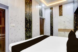a bedroom with a white bed and black and gold stripes at Super Hotel O Radha kunj By Namasya Retreat International in Prayagraj +21 photos