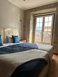 a bedroom with a large bed with a large window at Alojamento Central in Chaves +38 photos