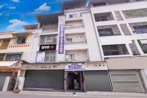 un bâtiment blanc avec un panneau devant dans l'établissement Hotel O Moonlight Residency, à Mumbai