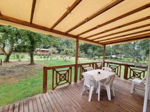 a wooden deck with a table and chairs on it at Les Palafitos in Luglon