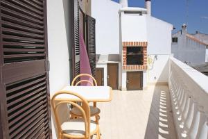 a balcony with a table and chairs on a building at Vivenda Costa in Odeceixe