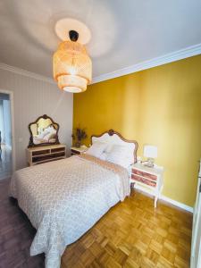 a bedroom with a bed and a yellow wall at Cangas centro en familia con encanto in Cangas de Morrazo