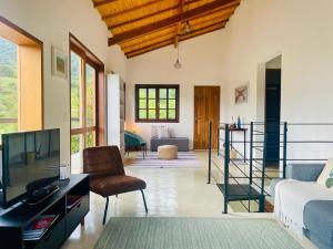 a living room with a tv and a couch at Casa Aurora, São Francisco Xavier SP in São José dos Campos