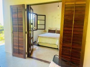 a bedroom with a bed and an open door at Casa Aurora, São Francisco Xavier SP in São José dos Campos