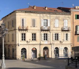 a large tan building with windows and balconies at Domo de Logu TÀTARI ANTIGA in Sassari