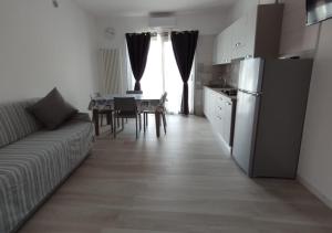 a living room with a couch and a table and a kitchen at La libellula blu in Vieste
