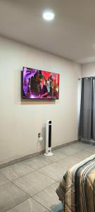 a room with a flat screen tv on a wall at Habitación Arándano in Ciudad Guzmán