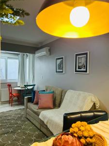 ein Wohnzimmer mit einem Sofa und einer gelben Decke in der Unterkunft 150 m da Catedral de Pedra - Centro de Canela in Canela
