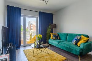 a living room with a green couch and a window at Lumina I Premium Apartments with Balcony I Parking I Pasaż Łódzki in Łódź