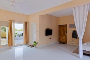 Moonlight Manor- Luxury Escape في بانغالور: غرفة نوم بها سرير وتلفزيون ونافذة