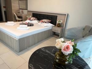 a bedroom with a bed and a vase of flowers on a table at Ida Beach in Mamaia Sat/Năvodari