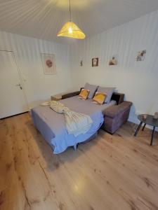 Un dormitorio con una cama y un sofá. en Le 102 - appart-sympa - T2, patio, jardin et cave - Larmor-Plage, en Larmor-Plage