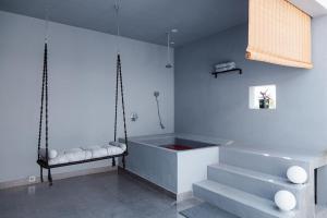 Moonlight Manor- Luxury Escape في بانغالور: حمام مع حوض يتأرجح والسلالم