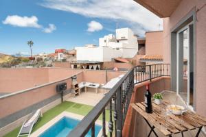 a balcony with a pool and a table with a bottle of wine at Hermosa Vista Tejina in Guía de Isora