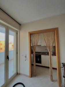 Habitación con cocina con cortinas en la puerta en Casa vacanze Colle della Minerva, en Otranto