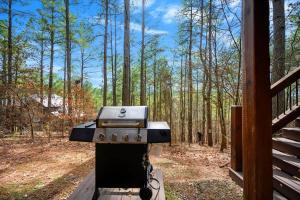 - un barbecue assis sur un support dans les bois dans l'établissement Heaven Sent - Sauna & Jacuzzi - Mini Golf, à Stephens Gap