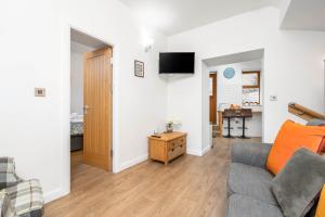 a living room with a couch and a tv at Kinder Apartment Central Glossop in Glossop
