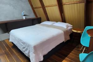 a bedroom with a bed with white sheets and a table at Pousada Cocobeach Adventure - Miracema do Tocantins in Palmas
