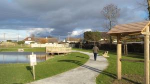 a person walking down a path next to a lake at Gite Les Oiseaux in Le Tréport