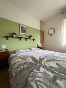 a bedroom with a bed and a green wall at Villa Magnolia Oliveti relax e privacy con panorama mozzafiato in Crosano