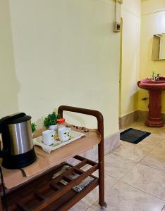 un tavolo con due tazze e una pentola sopra di Heritage Inn Homestay Sivsagar a Sibsāgar