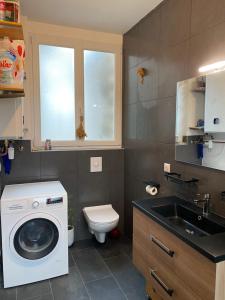 a bathroom with a washing machine and a sink at Village vacations in Guarguale