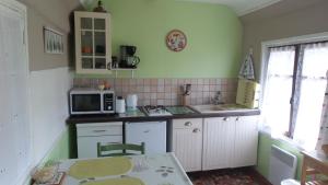 a small kitchen with a sink and a microwave at Gite Les Oiseaux in Le Tréport