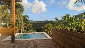 a pool on a deck with a view of the mountains at Tropical Haven 2 pieces contemporain avec piscine in Les Trois-Îlets