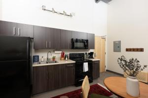 a kitchen with a black refrigerator and a table at Cream City 2BR Apt - Just 3 Blocks to Fiserv with Gym and Parking in Milwaukee