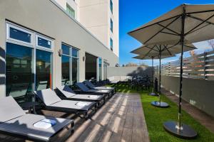 阿尔伯克基Fairfield by Marriott Inn & Suites Albuquerque Uptown的大楼里一排躺椅和一把遮阳伞