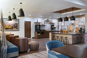 阿尔伯克基Fairfield by Marriott Inn & Suites Albuquerque Uptown的厨房以及带酒吧和椅子的客厅。