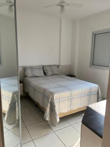 a bedroom with a bed and a glass shower at Apto com Ar condicionado e churrasqueira in Praia Grande