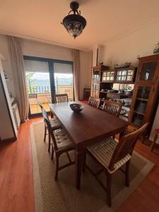 a dining room with a wooden table and chairs at Duplex Bueu Vistas con terraza in Bueu