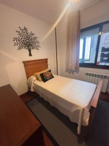 a small bedroom with a bed and a window at Duplex Bueu Vistas con terraza in Bueu