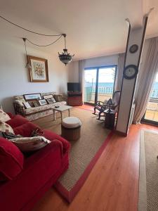 a living room with a red couch and a table at Duplex Bueu Vistas con terraza in Bueu +16 photos