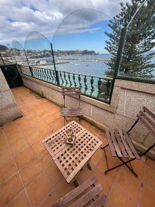 a balcony with a table and two chairs and a view of the water at Duplex Bueu Vistas con terraza in Bueu