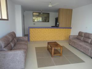 a living room with two couches and a table at Sanvika Hotels & Service Apartments in Coimbatore