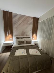 a bedroom with a large bed with two towels on it at B&B IV Novembre Apartment- Forum Assago - Stadio San Siro - Duomo Milano Centro - fiera Milano in Corsico